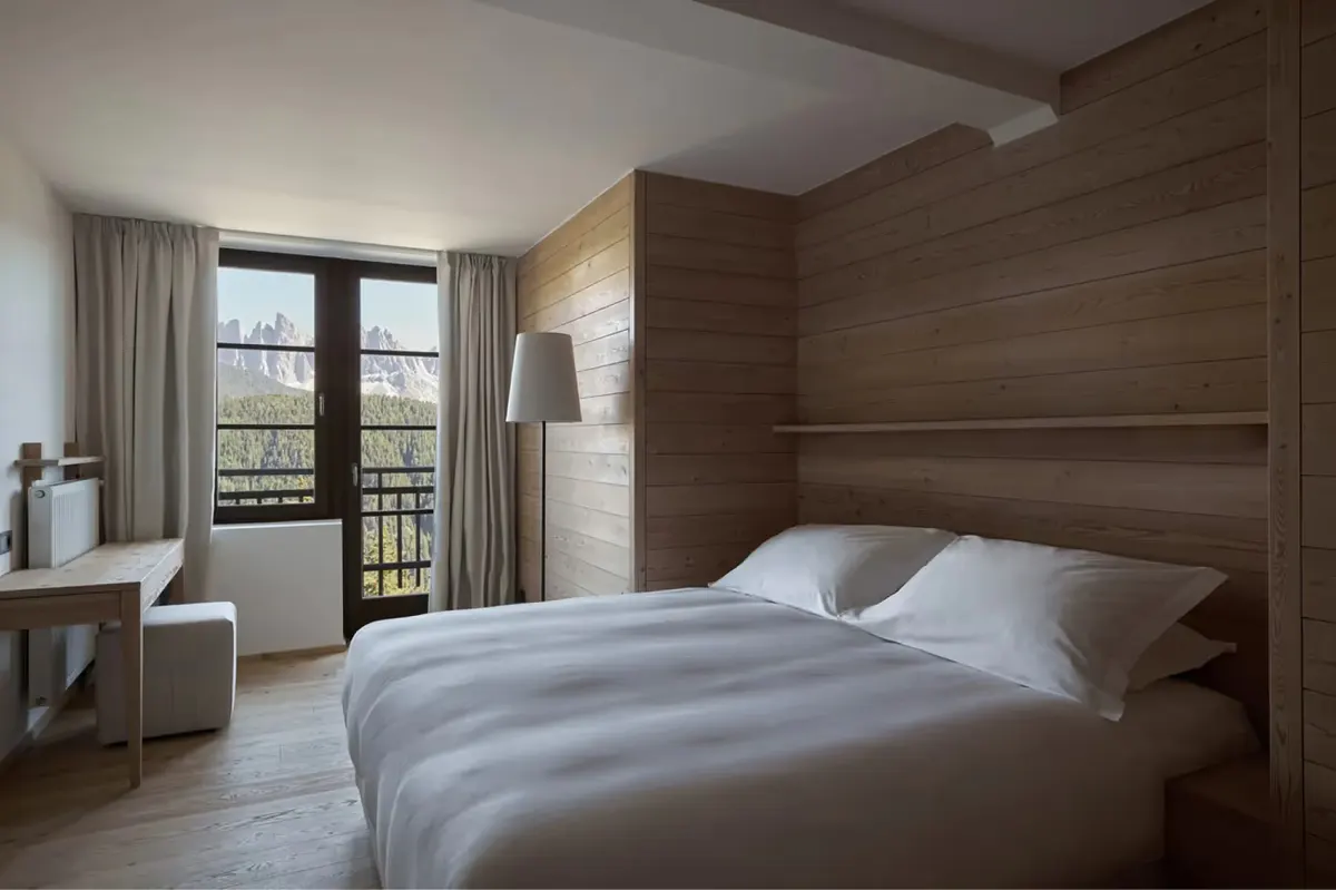 A spa treatment room with a stone bench, minimal natural wood cabinetry, and mountain views