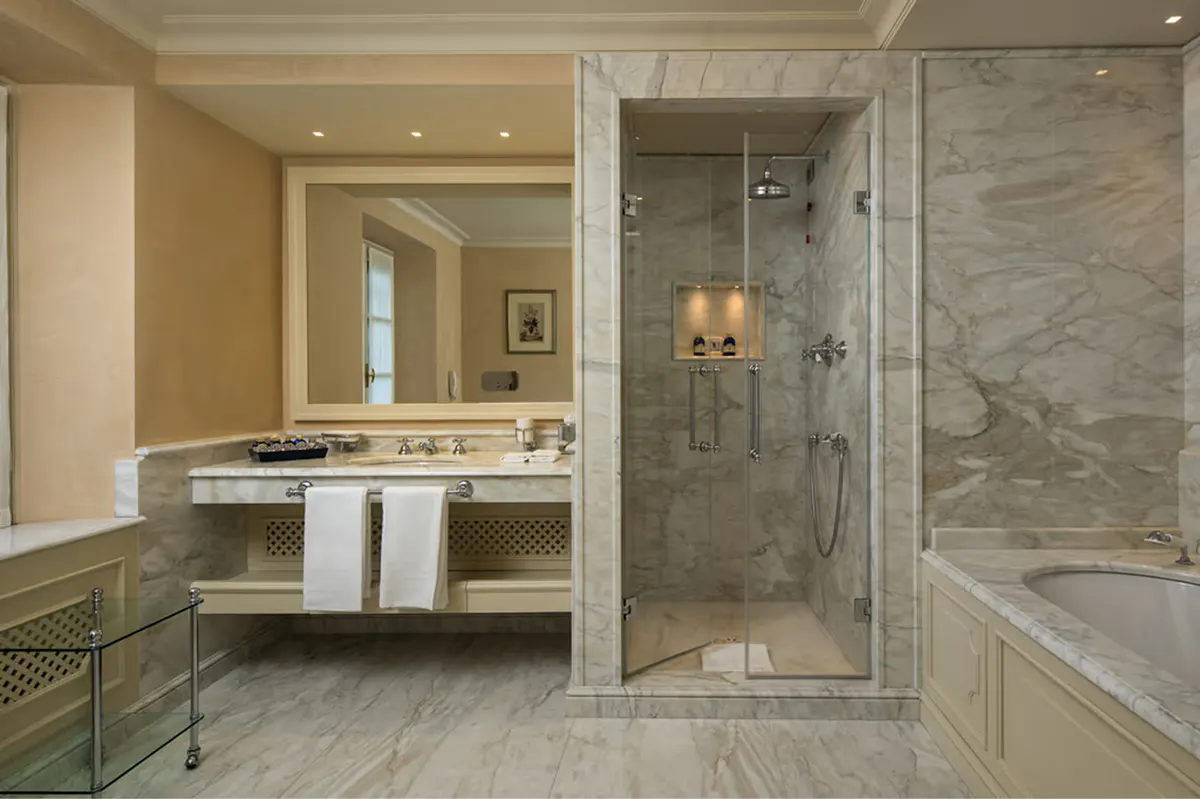 Marble bathroom with vessel sink, glass walk-in shower, and neutral stone finishes