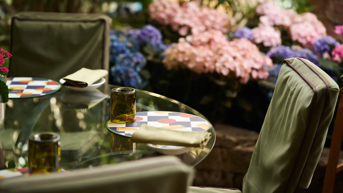 Table setting with wine glass and pink and blue hydrangea blooms in the background