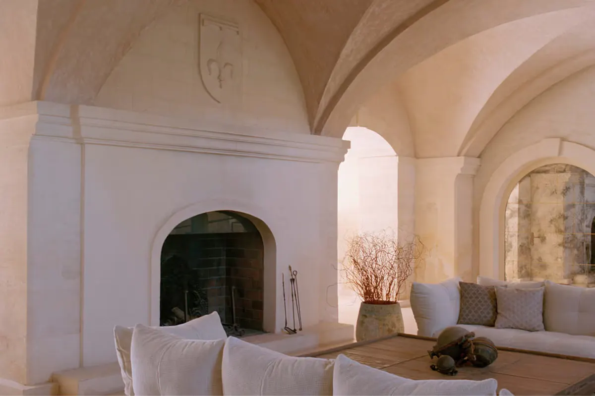 Modern interior with barrel vaults, arched doorway, and understated seating arrangements