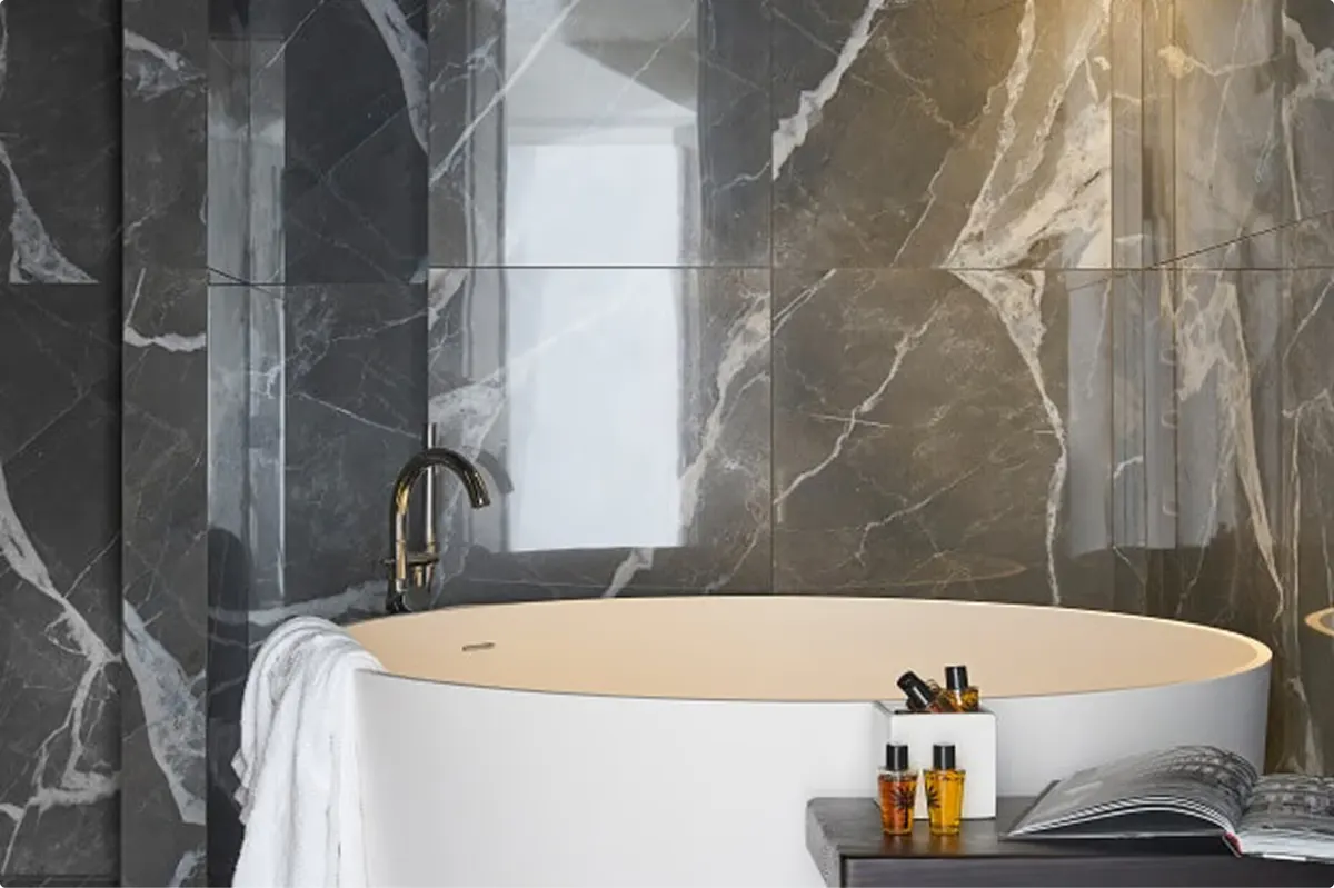 Spa-style bathroom with white freestanding tub and decorative vessel mirror