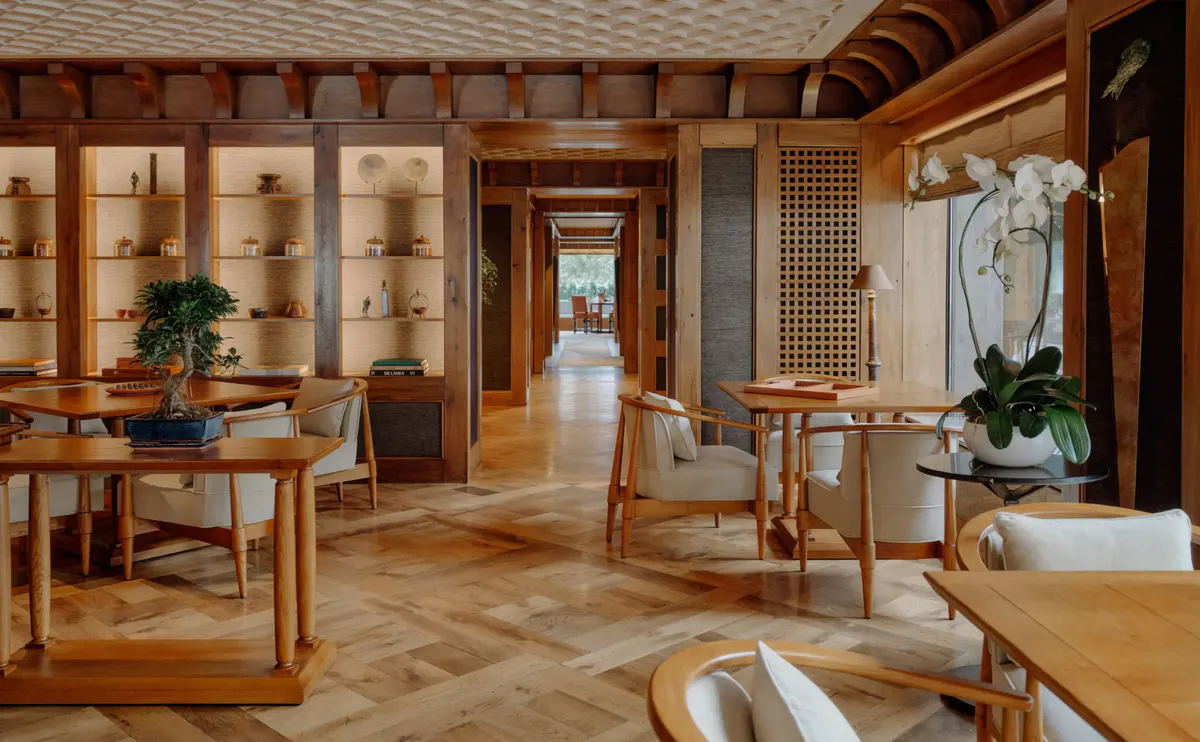 Nama dining room with ceramic display shelving, bonsai, and tables set beneath a beamed ceiling