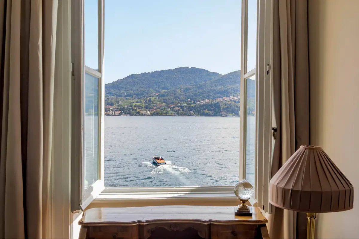 Lake Como view from a suite window with a small lamp on the sill
