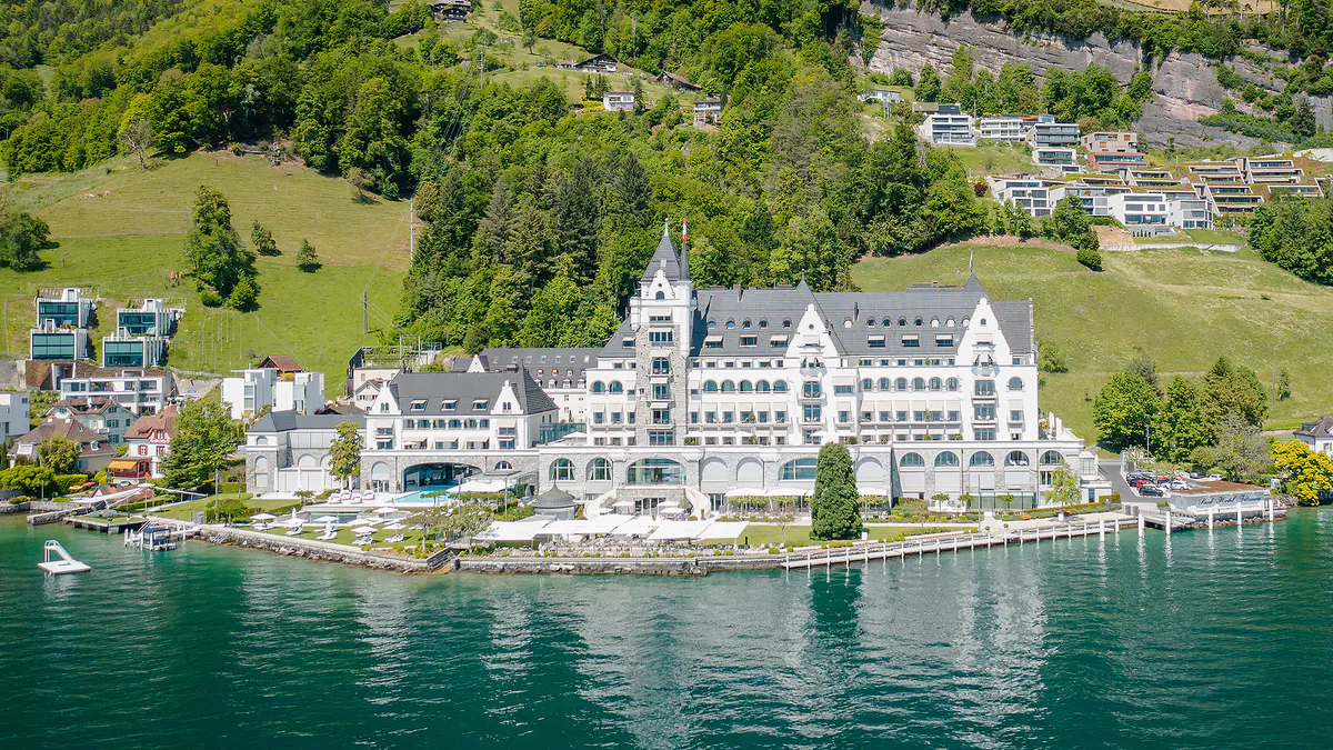 Hotel positioned on the lake with forested hillsides in background
