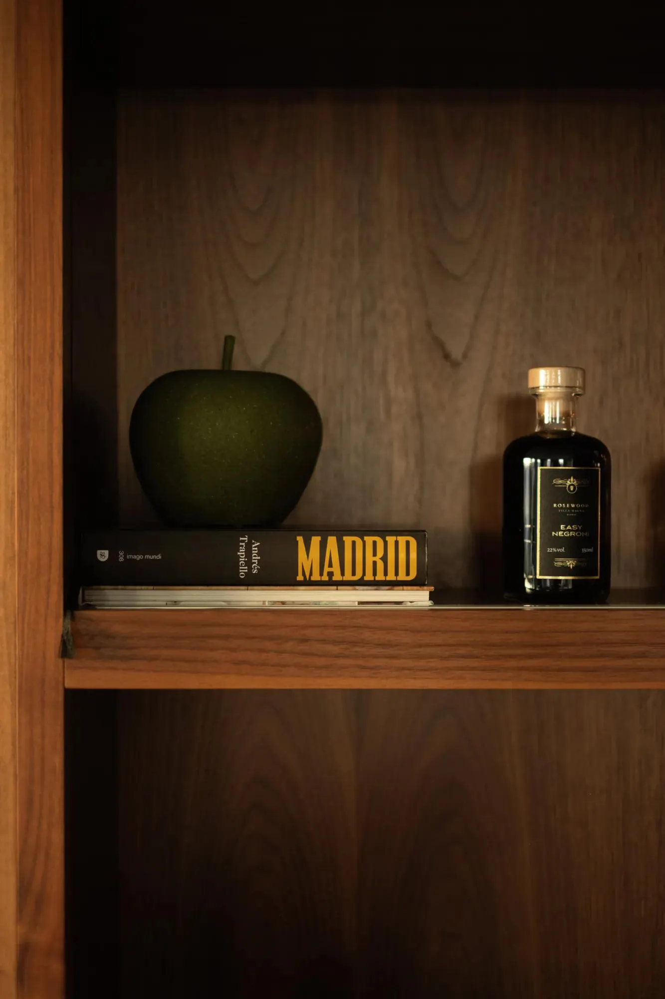 A quiet still life on a walnut shelf in Madrid