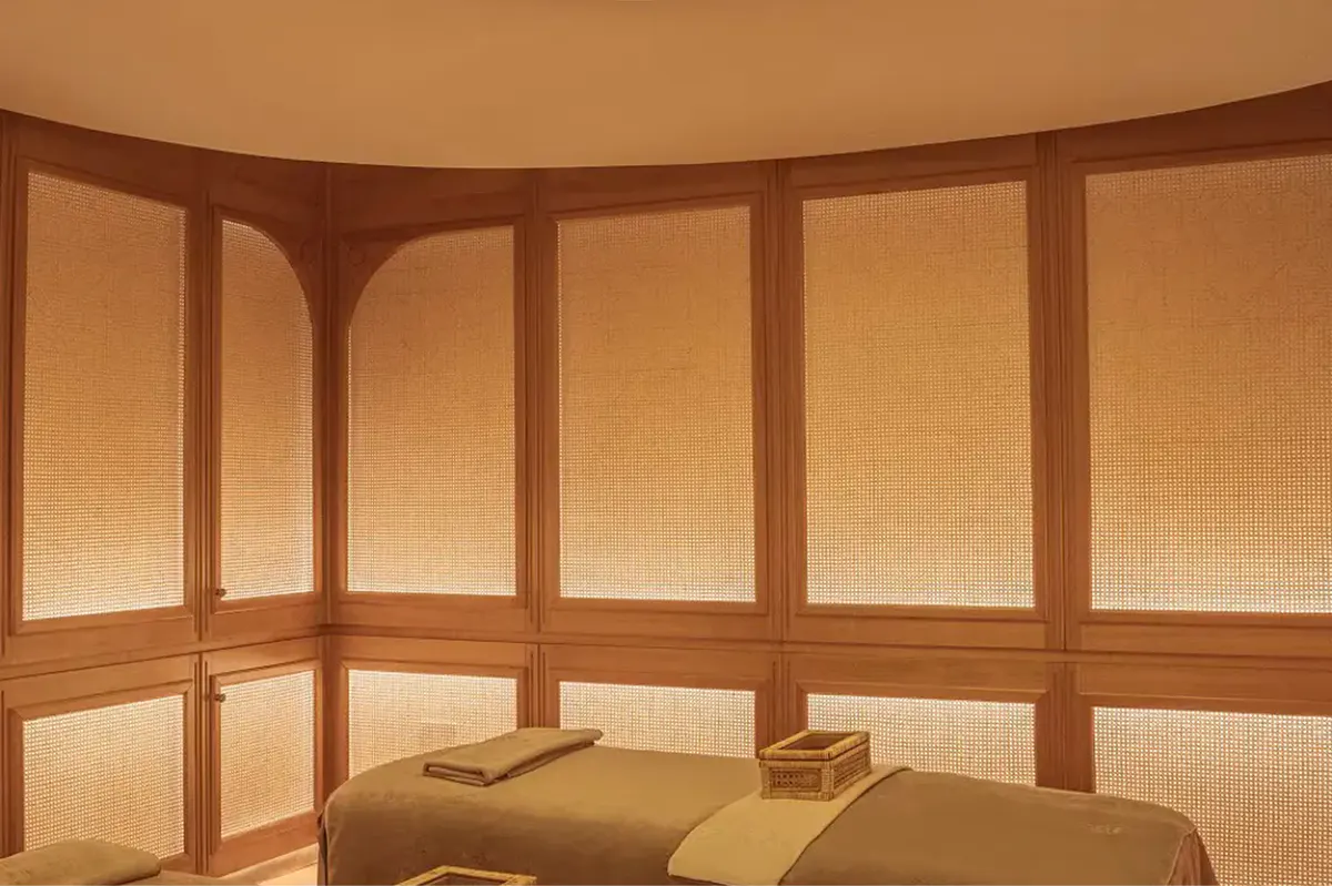 A curved sauna interior with wooden bench seating and light wood walls