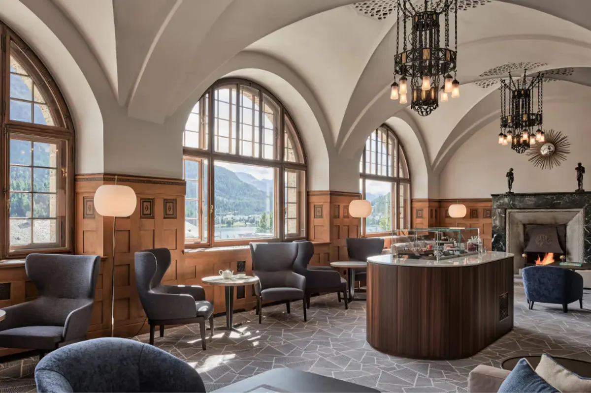 Grand lobby with arched ceilings, wooden bar, chandeliers, and alcove seating areas