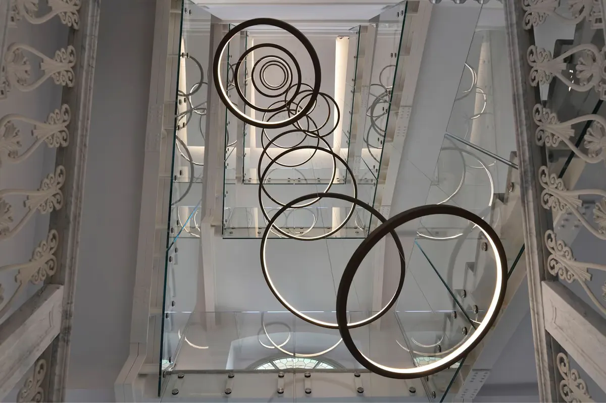A geometric ceiling detail with white molding and circular patterns