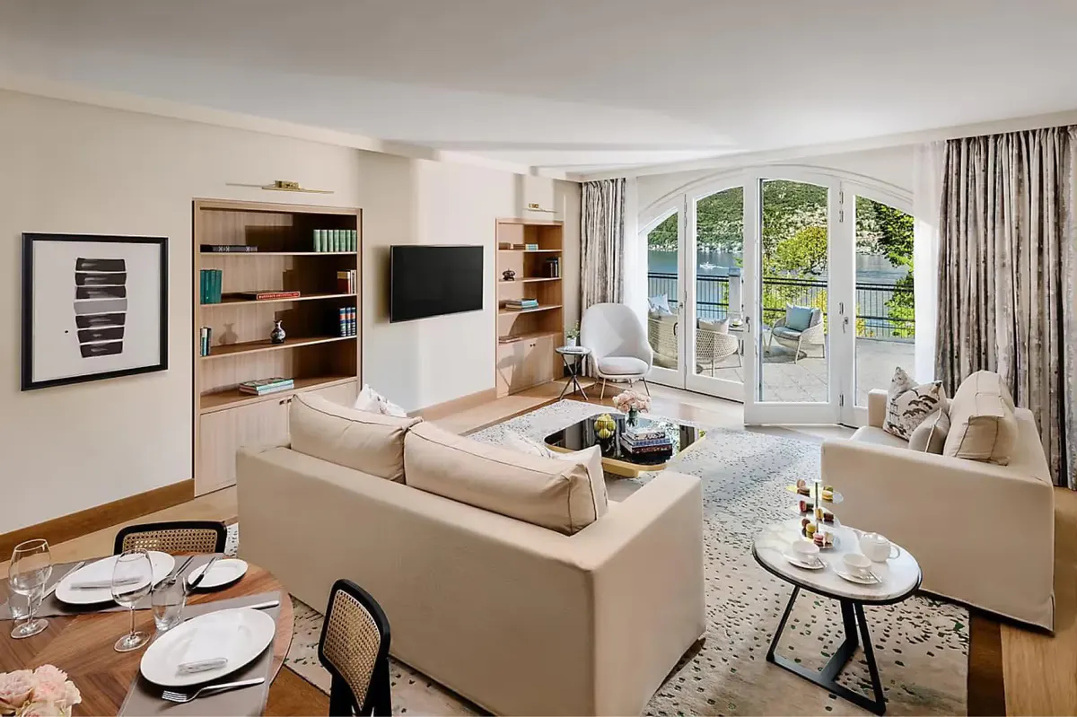 Living room with cream sofa facing lake views through glass doors and built-in shelving