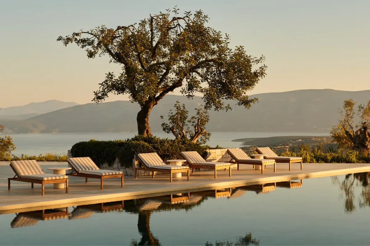 Long shallow pool with cypress trees and mountain horizons