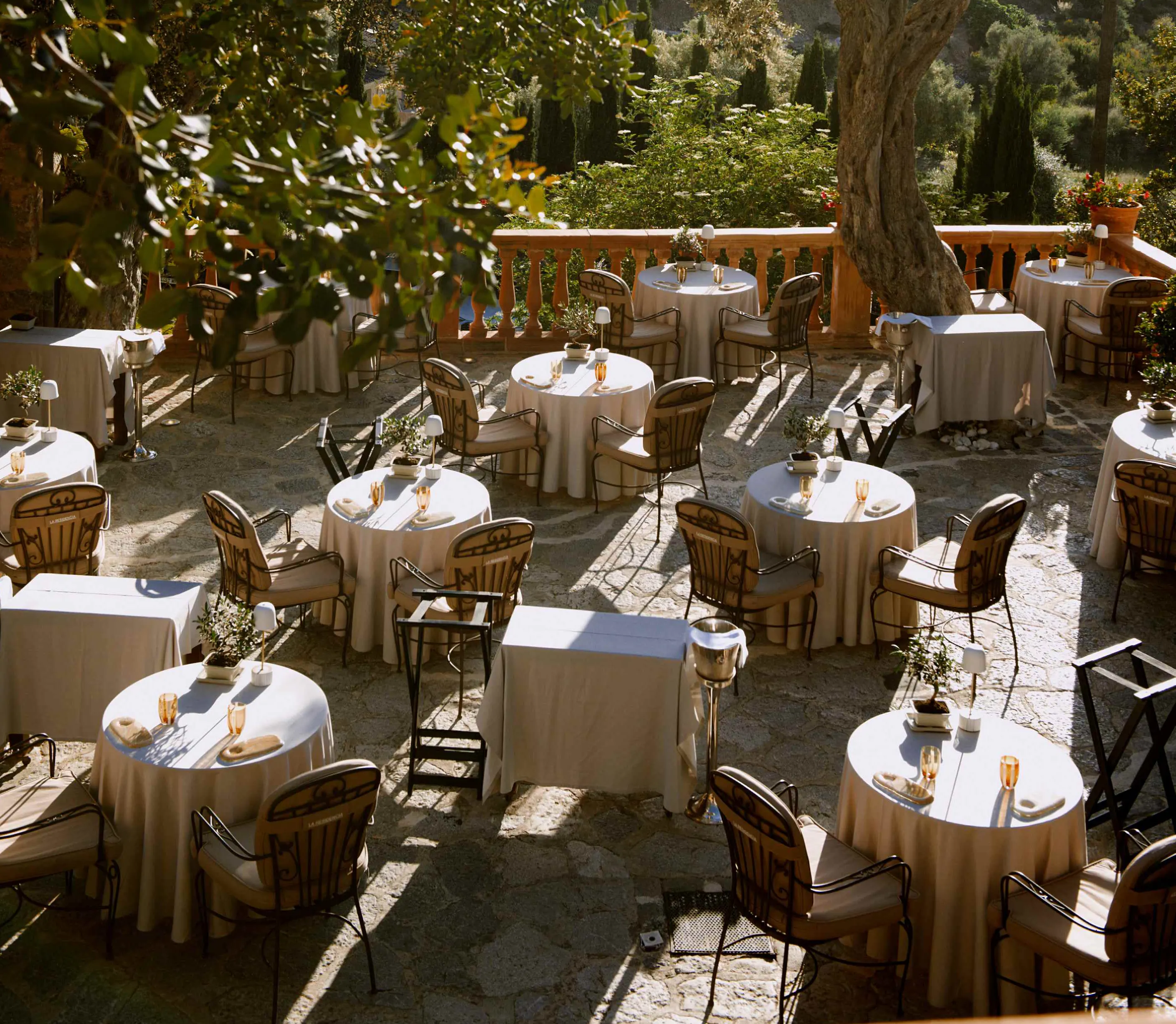 Candlelit terrace tables beneath old trees in Mallorca