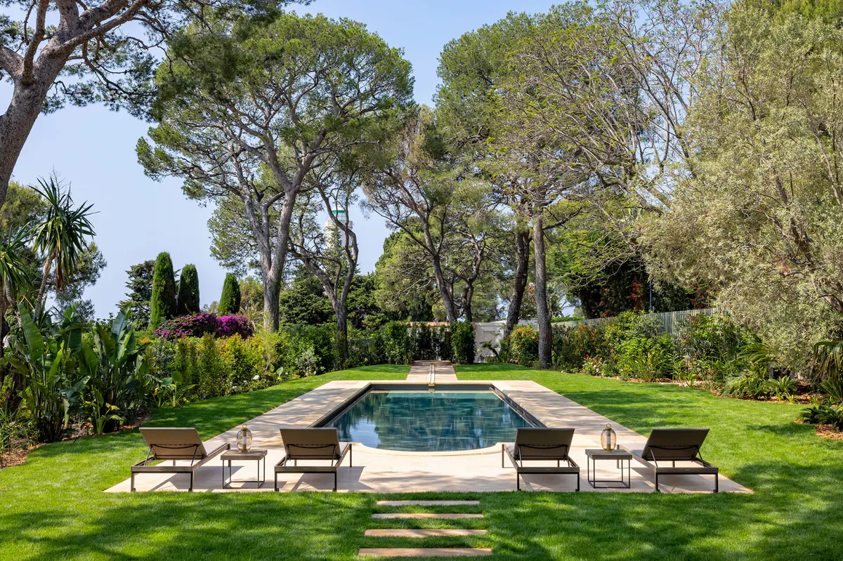 Sunken pool surrounded by mature trees and lush Mediterranean plantings