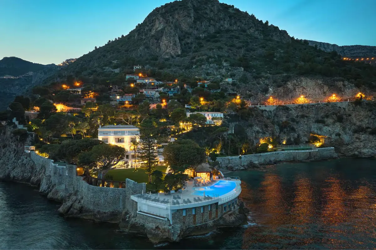 Evening view of the hotel compound on a cliffside with lit structures