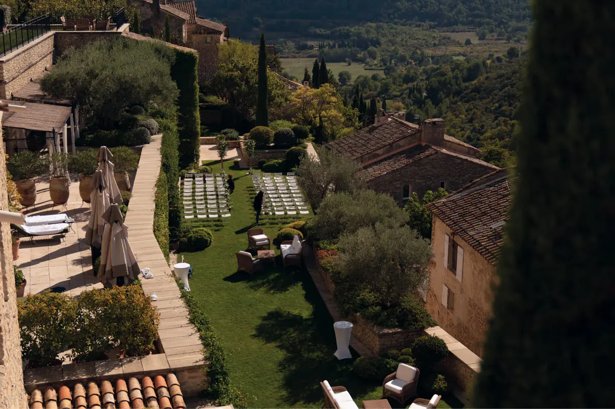 Aerial view of stone terraces, gardens, and distant valley from the hilltop property