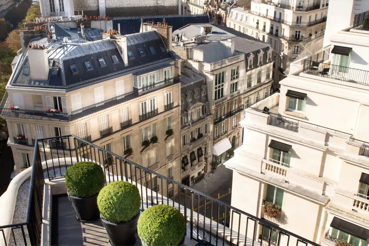 A view from a balcony looking down at Haussmann building facades and the Seine