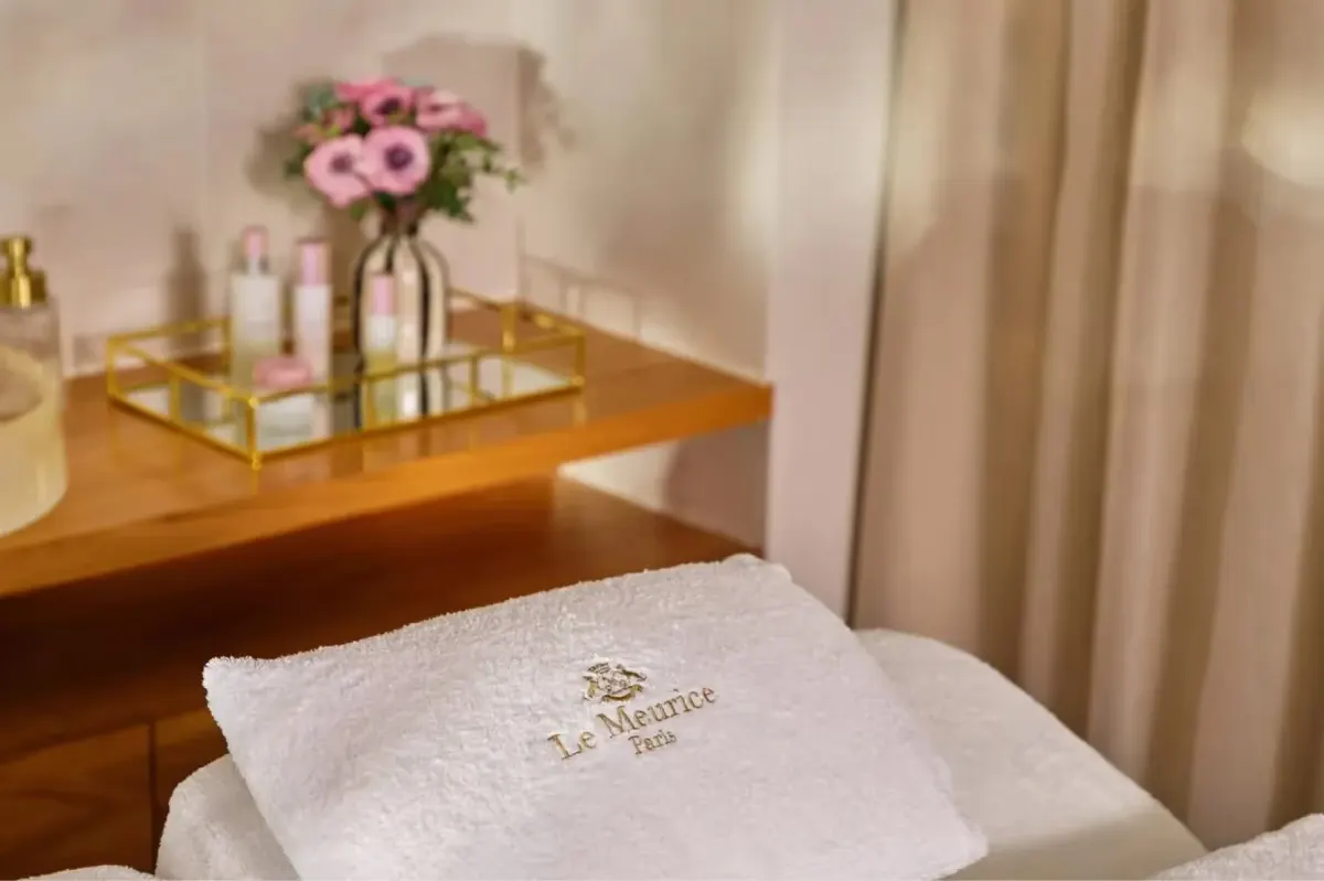 A spa treatment area with fresh flowers, towels, and wellness products displayed
