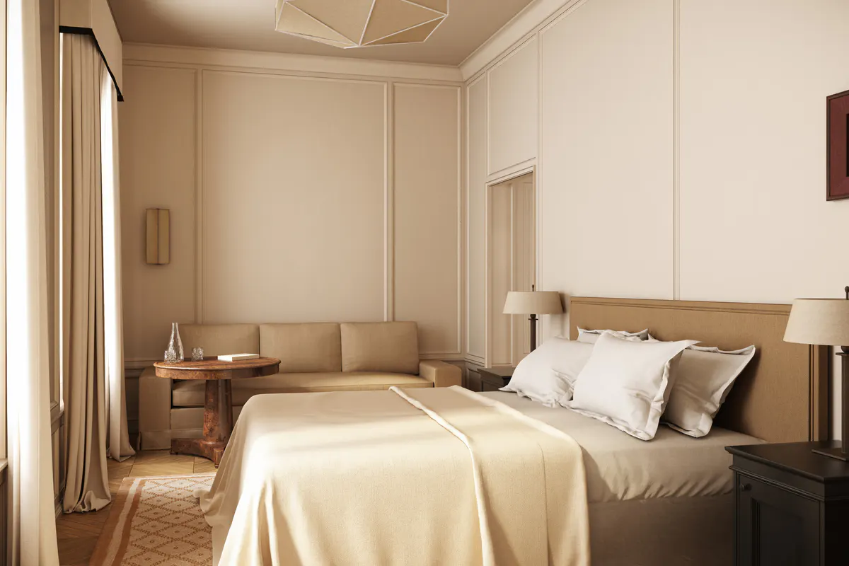 A bedroom with pale walls, a low bed with tan bedding, and minimal furnishings