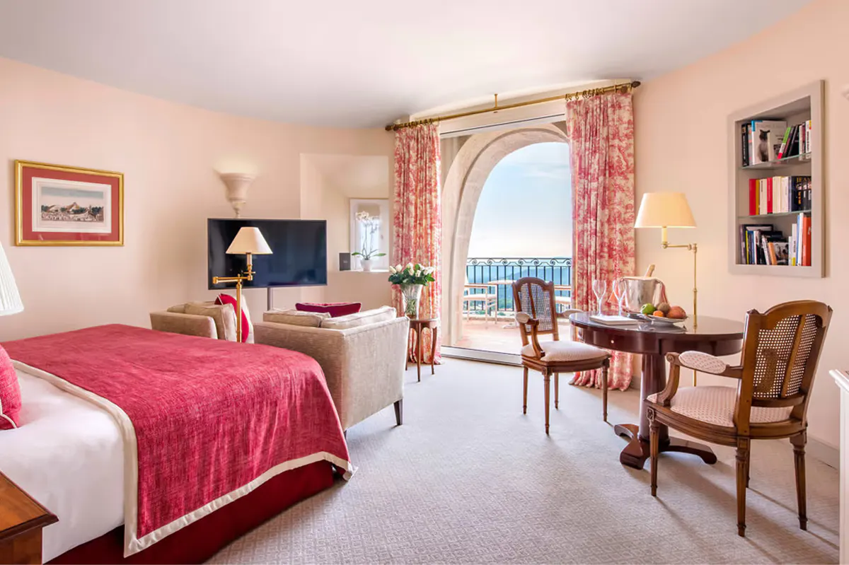 Suite bedroom with French doors opening to a terrace with sea views