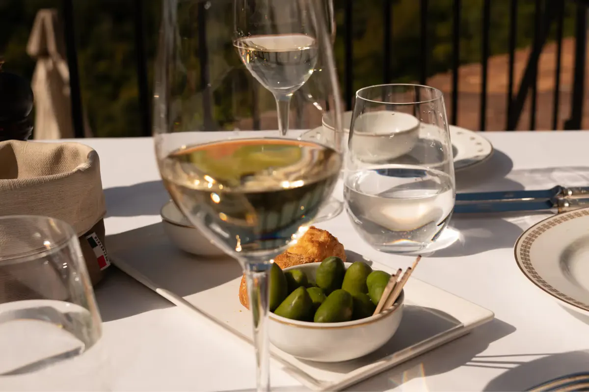 Dinner service on white tablecloth with terracotta views beyond the railing