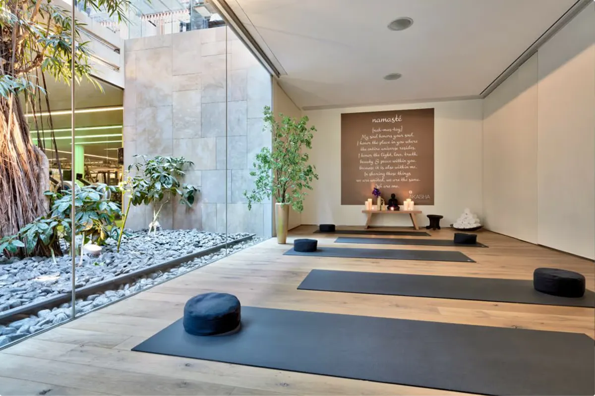 Yoga studio with mats, indoor plants, wood flooring, and minimalist design