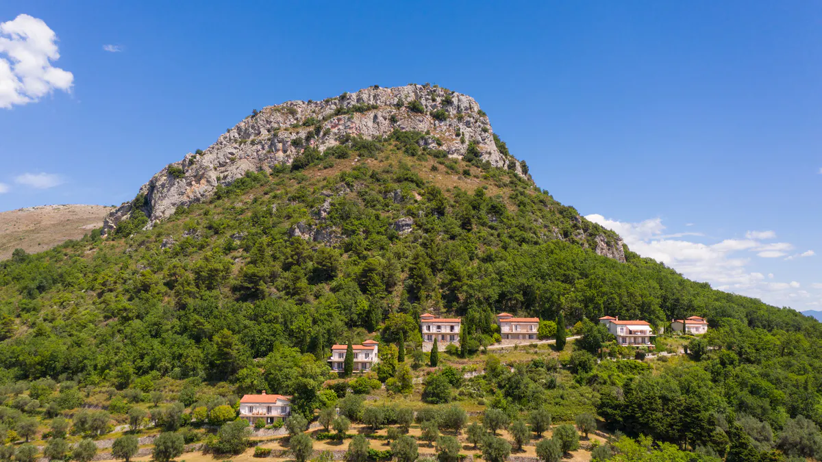 Rocky hillside with green landscape and distant château buildings