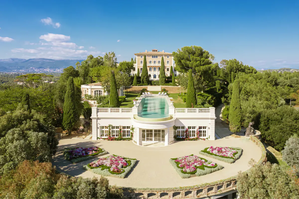 Château and pool complex with Alps visible in distant background, manicured grounds