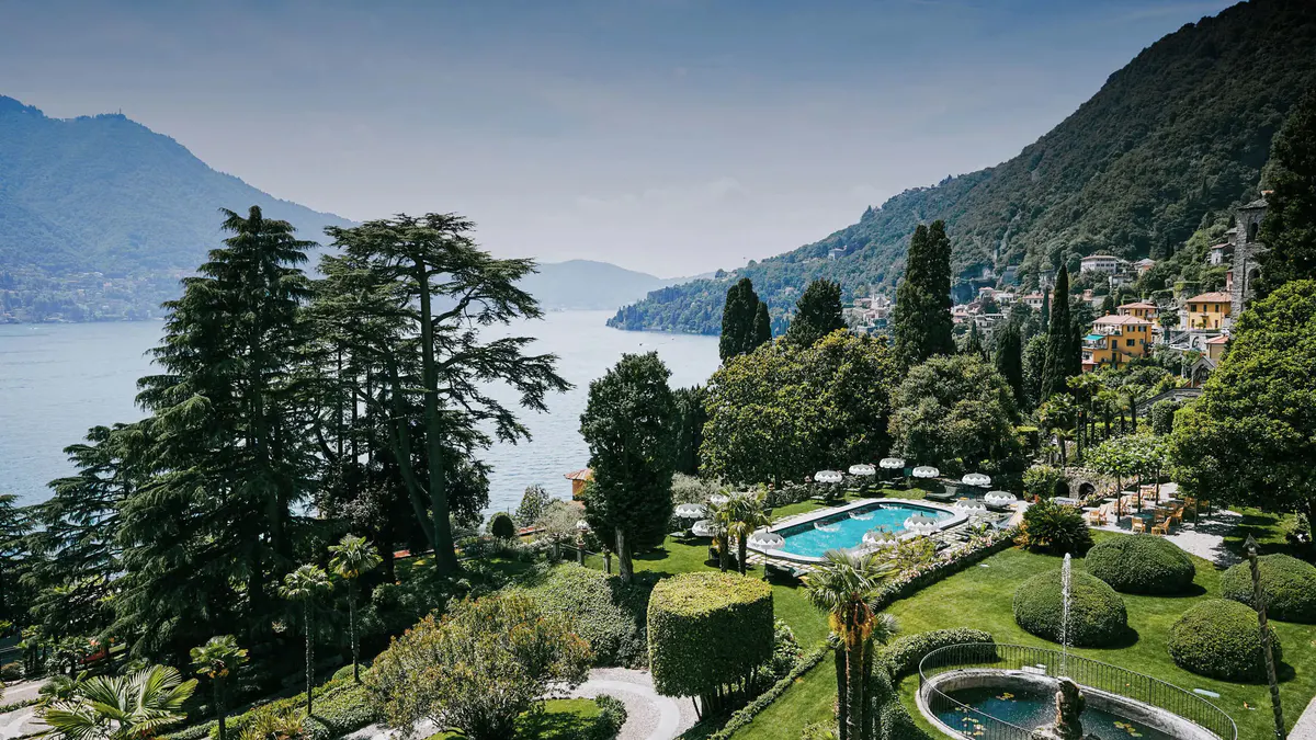 Terraced grounds with a pool and manicured gardens overlooking Lake Como and distant mountains