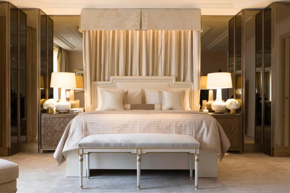 A grand suite with coffered ceiling, gilt furniture, and elegant cream upholstery