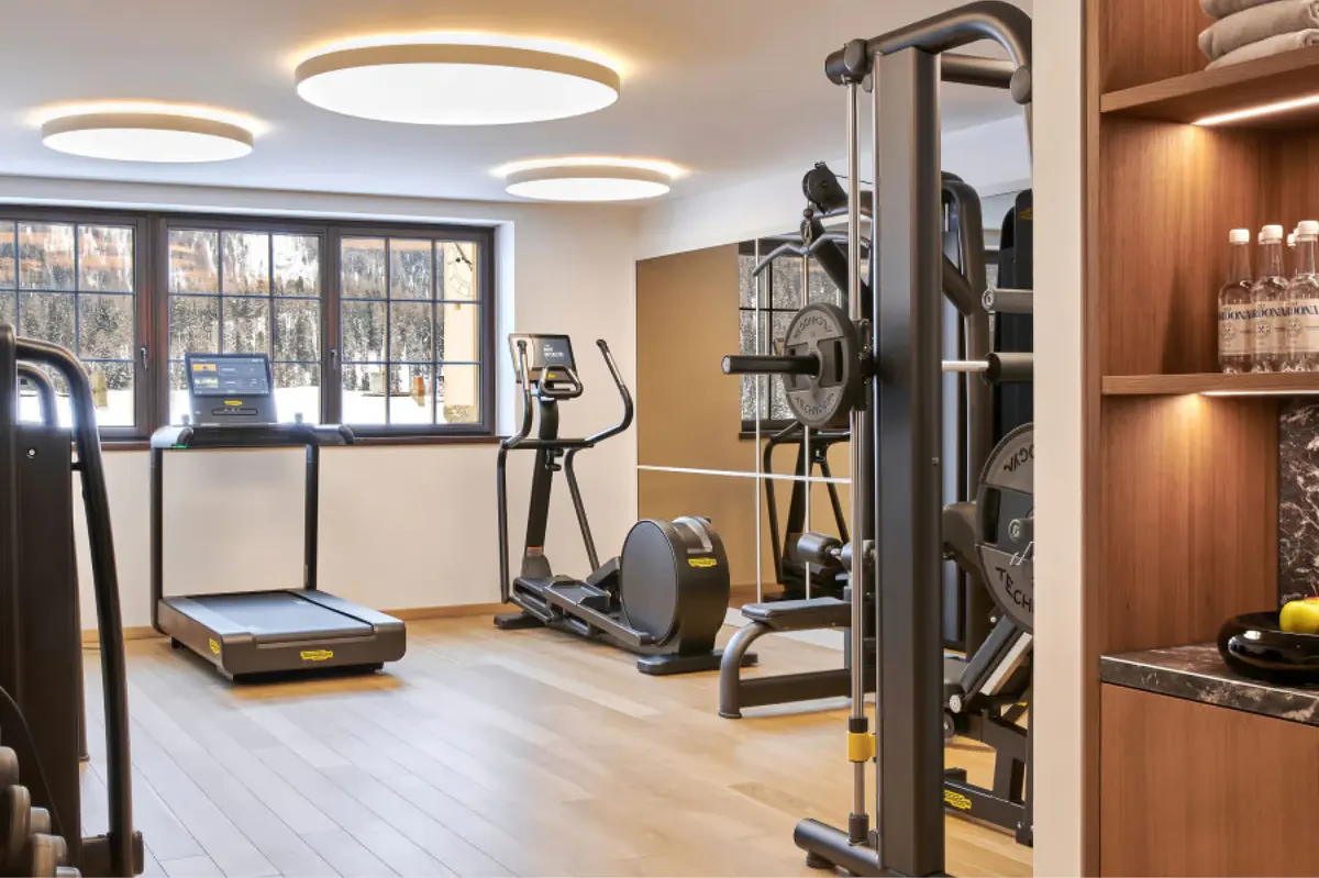 Fitness center with treadmill, exercise equipment, and natural light from tall windows
