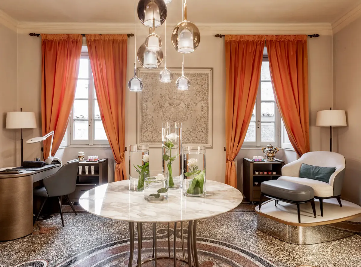 Elegant sitting room with round table, pendant lights, and red curtains