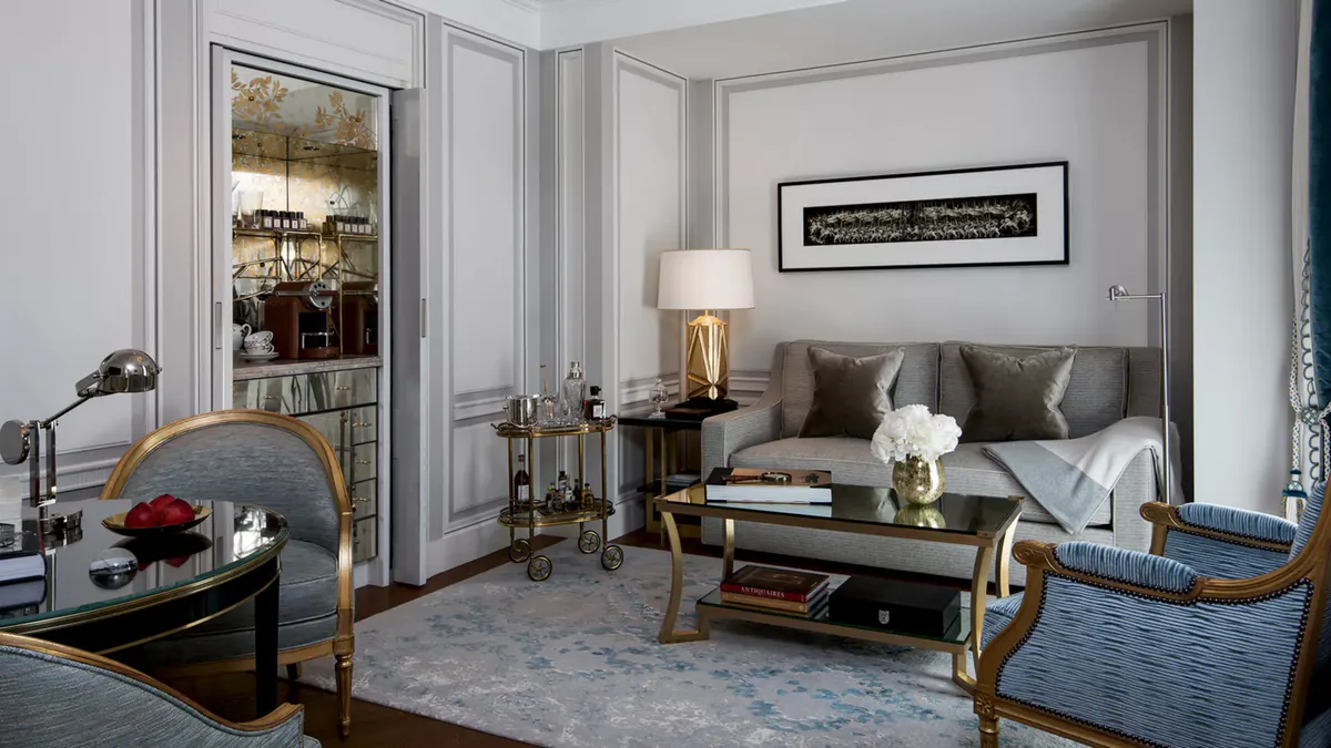 Bedroom with marble bathroom visible, ornamental mirrors, and soft neutral tones