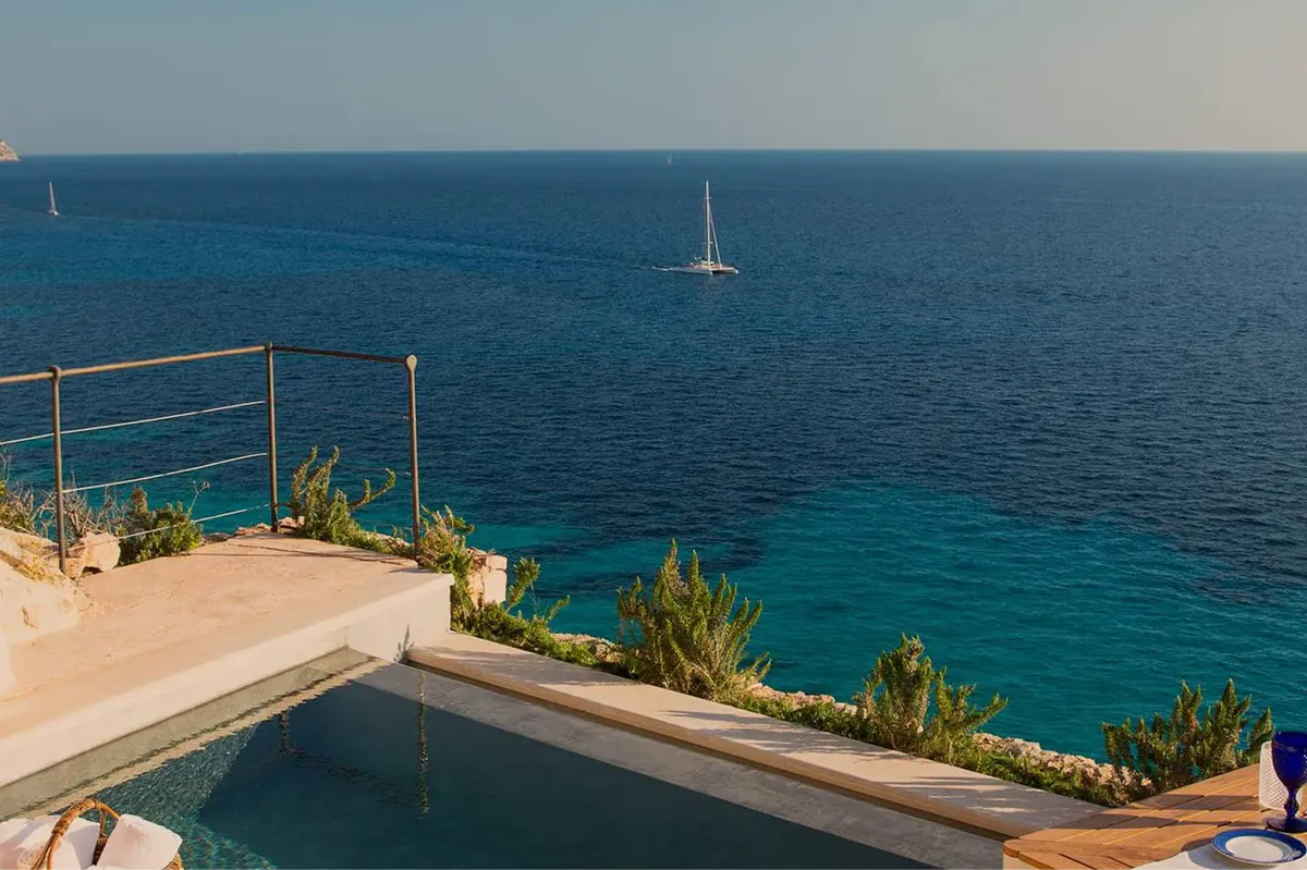 A covered deck with reclined loungers and panoramic bay views at sunset