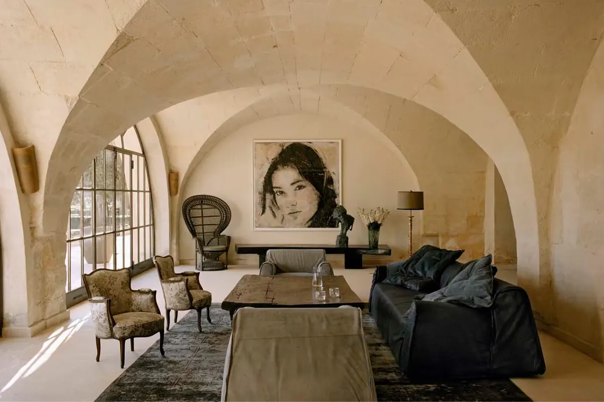 Vaulted limestone interior with barrel ceiling and simple furnishings in neutral tones