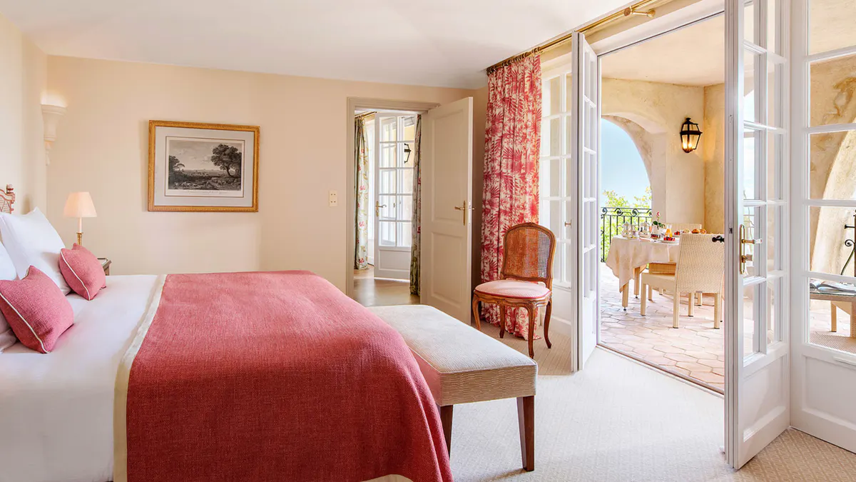Guest bedroom with pink bedding and access to a sitting area