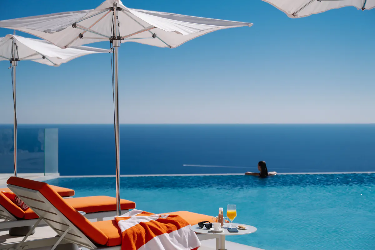 Pool lounge with white umbrella and turquoise water