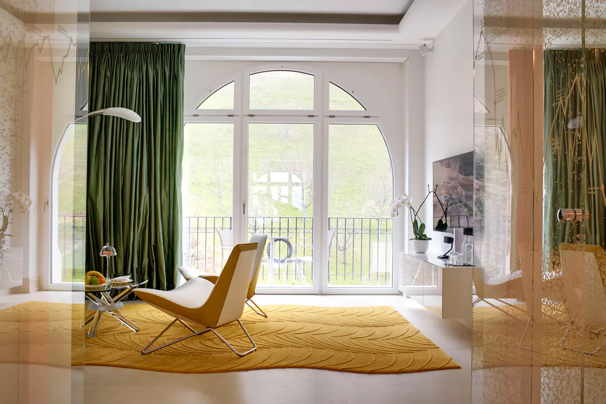 Bright room with arched windows, green drapery, and chaise lounge