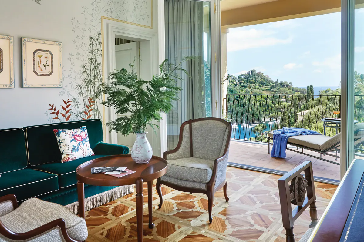 A hallway with arched doorways, botanical wallpaper, and light-filled spaces