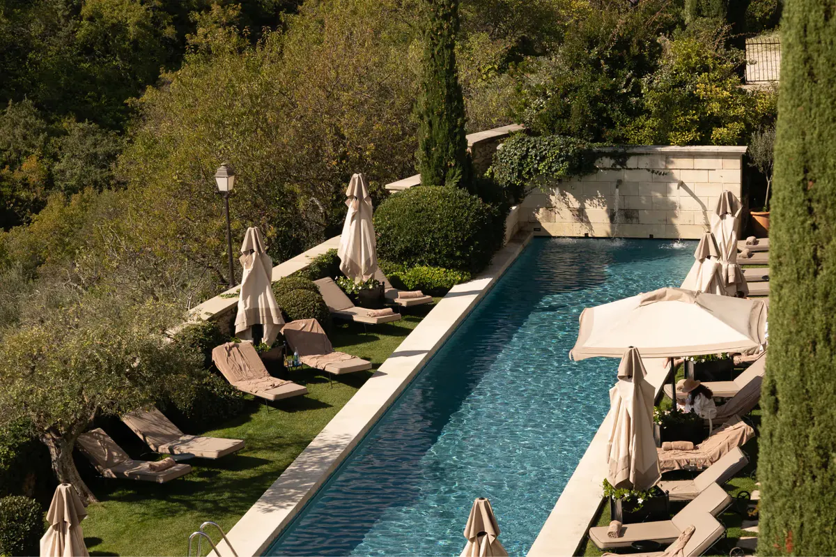 Aerial view of rectangular pool surrounded by cypress and manicured lawn