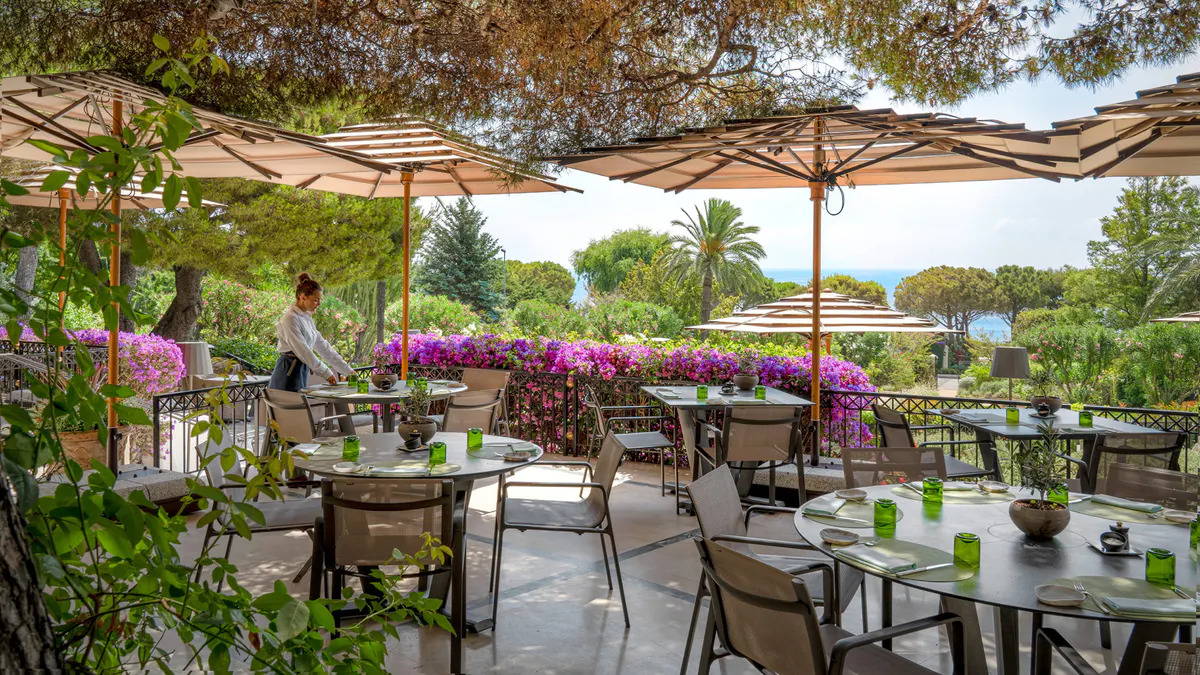 Outdoor terrace with parasols, flowering bougainvillea, and garden seating