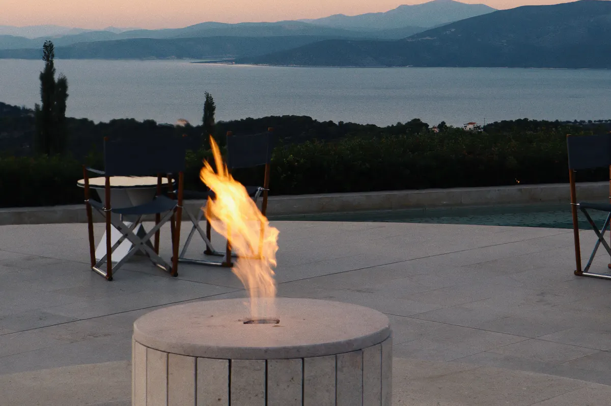 Intimate waterside dinner with fire feature at twilight