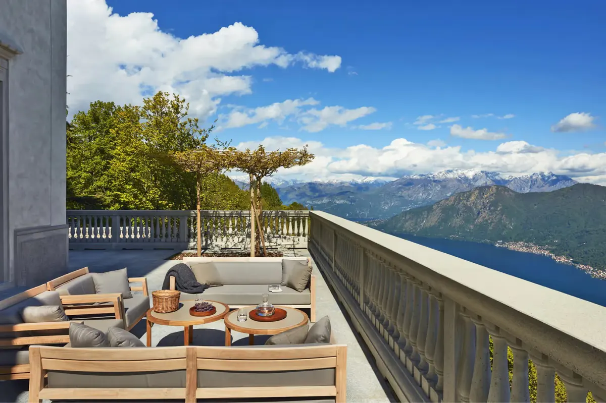 A raised terrace with seating and views across Lake Como to distant mountains