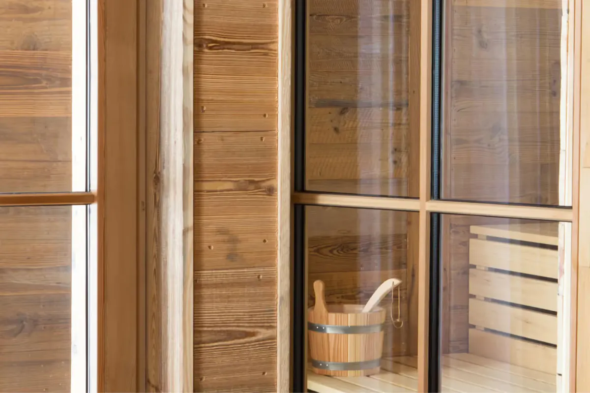 Wooden sauna interior with glass sliding doors