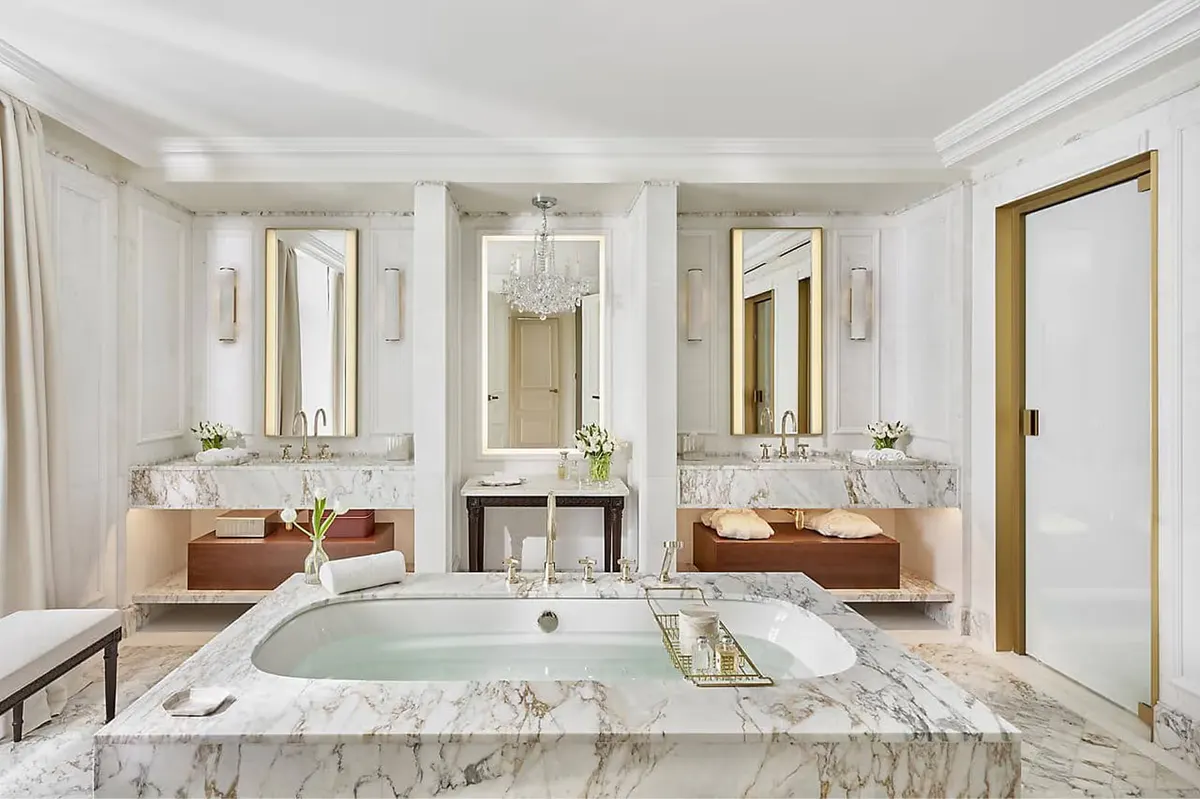 Spa bathroom with marble vanity, freestanding tub, and jewel-toned accents