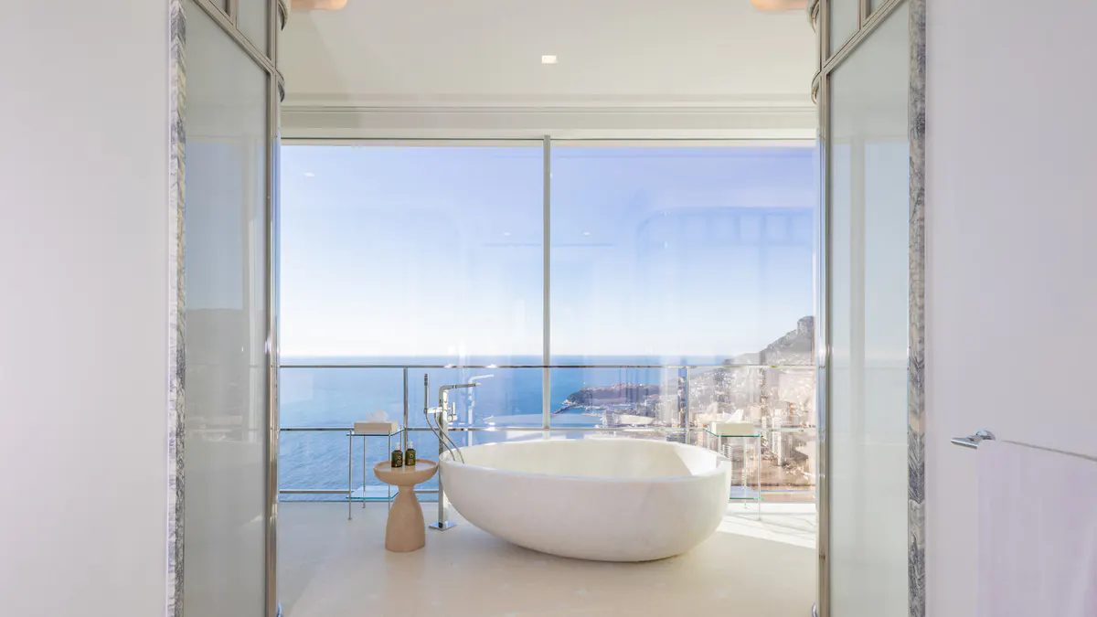 Freestanding tub with sea views through floor-to-ceiling windows