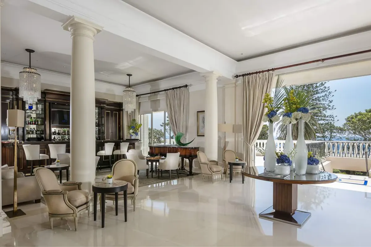A bright lobby with columns, furniture, and panoramic sea views