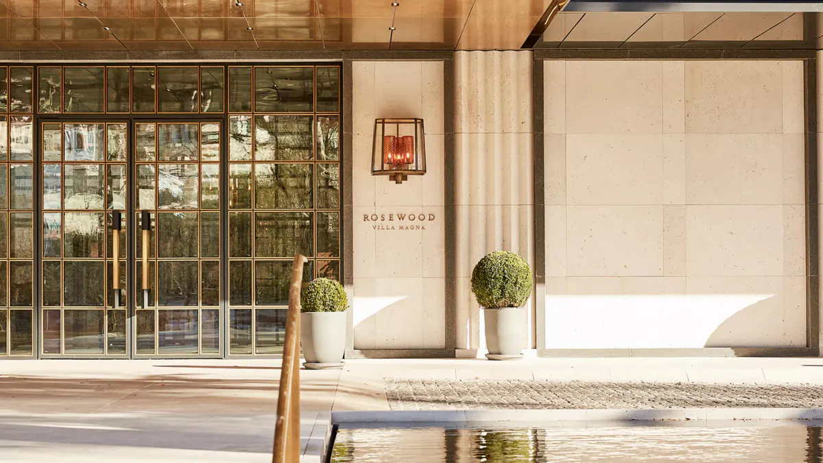 The hotel entrance with glass doors, archway, and warm wood tones