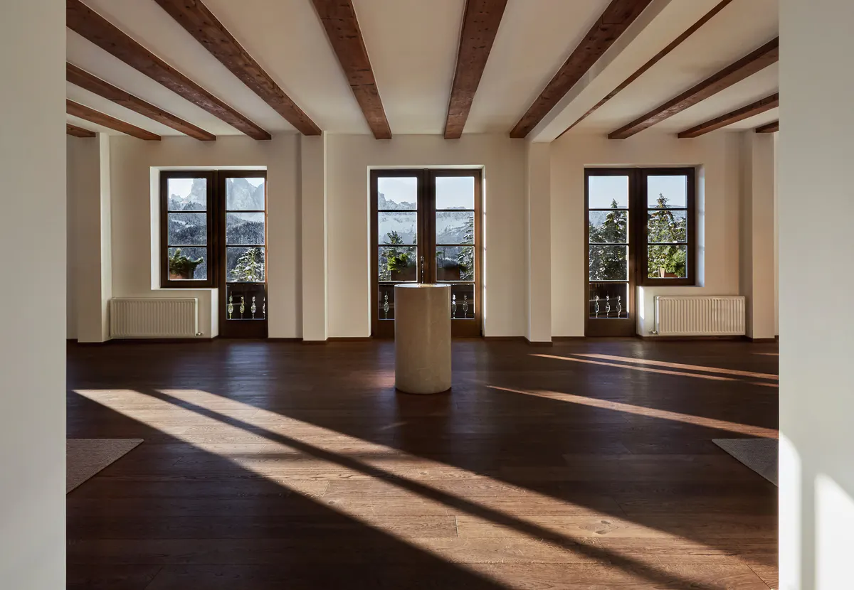 An interior corridor with light wood and concrete materials connecting different areas of the hotel