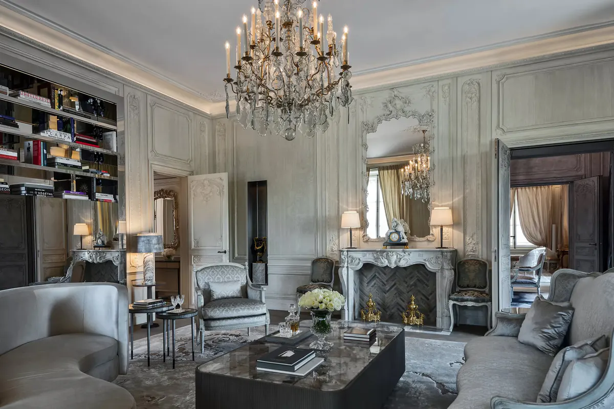 Formal suite with white marble fireplace, arched doorways, and pale color scheme