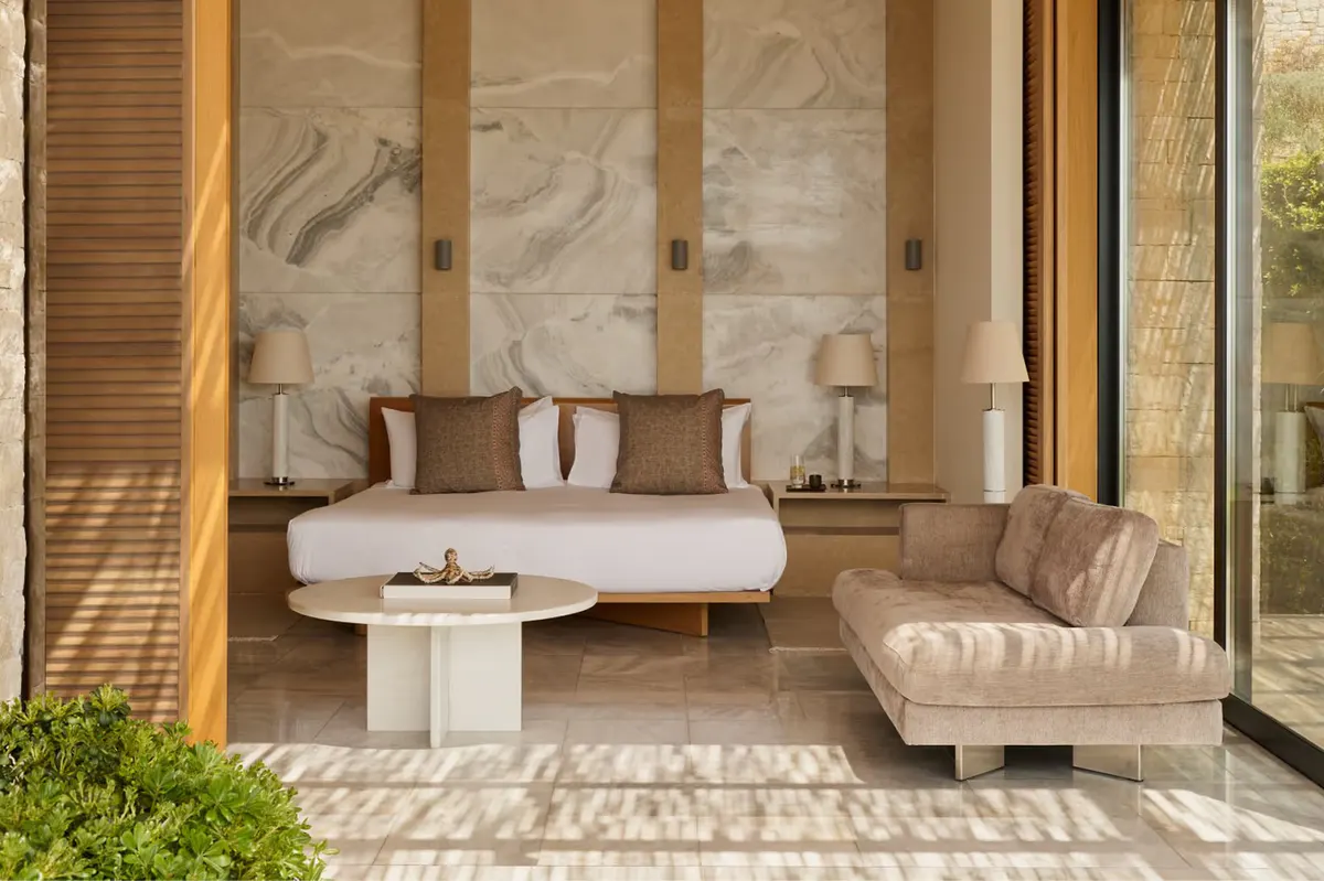 Pavilion bedroom with oversized marble headwall and neutral furnishings
