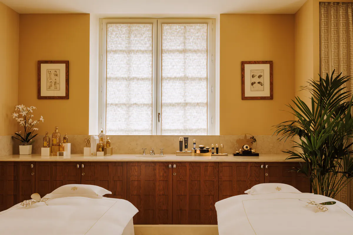 Spa room with black tile, wood cabinetry, and brass fixtures